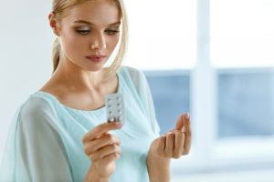 A woman holds birth control pills